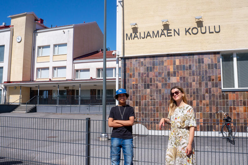 Oliver Viljainen ja Anne Palola seisovat aitaa vasten Maijamäen koulun edessä.