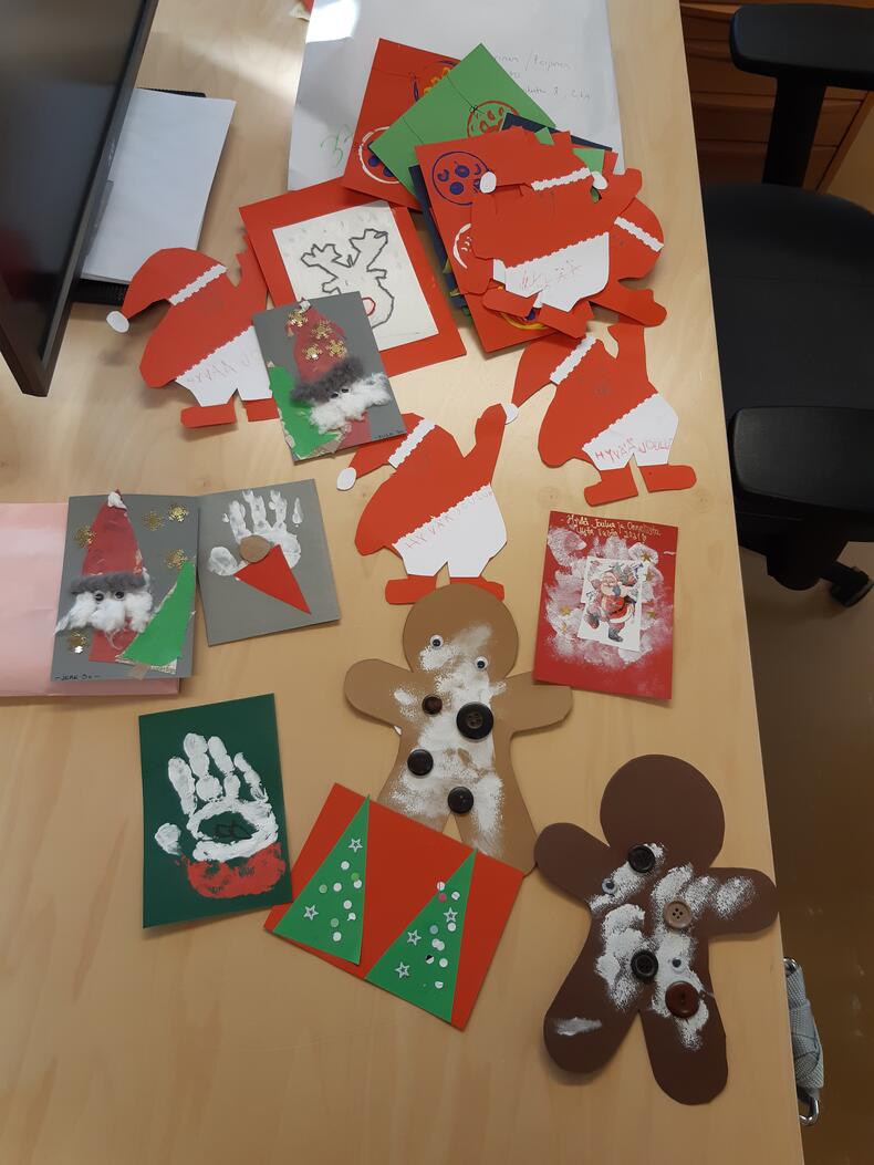Lasten tekemiä joulukortteja pöydälle levitettynä.