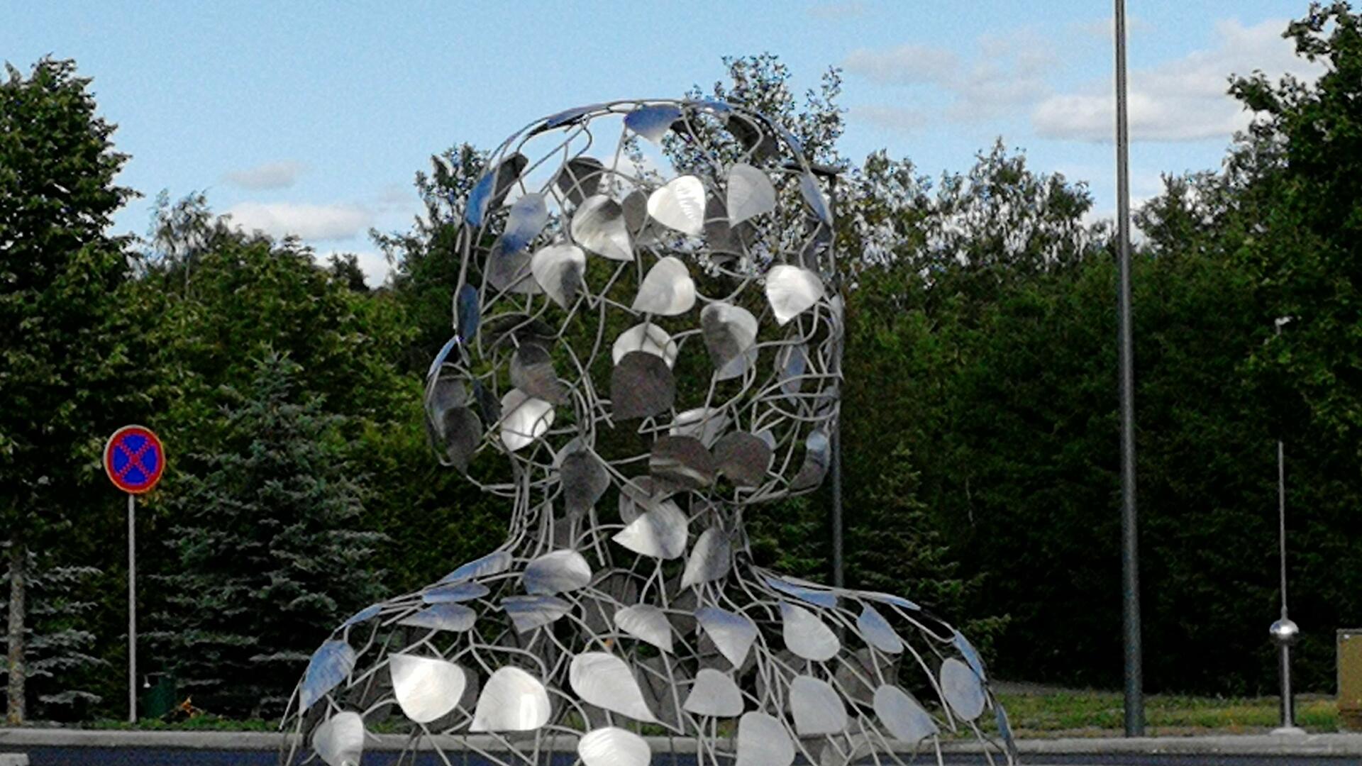 taideteos, jossa metallista tehty runko ja päälle kiinnitetyt lehdet muodostavat naisen rintakuvan